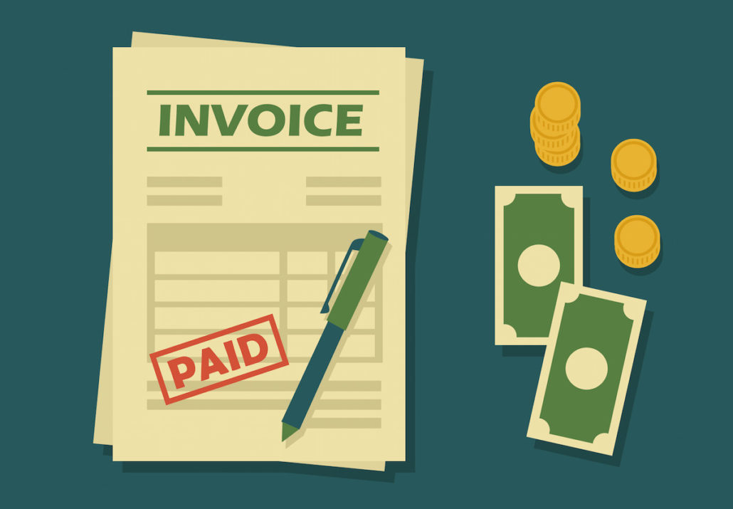 sample paid invoice form sitting beside loose money bills, coins and a pen